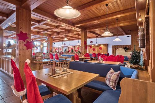 een restaurant met kerstmutsen op de tafels en stoelen bij Das Arber-Hotel am Rothbach in Bodenmais