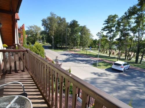 a balcony of a house with a car parked on the street at Florek in Dziwnów