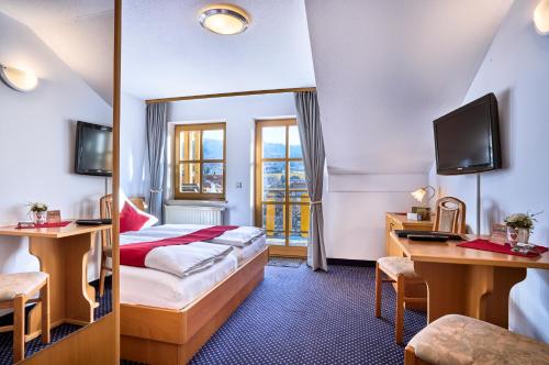 een hotelkamer met een bed en een bureau bij Das Arber-Hotel am Rothbach in Bodenmais