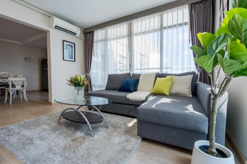 a living room with a couch and a table at Spacious 3BR near Impact, Don Mueang Airport & Pink Line MRT in Nonthaburi