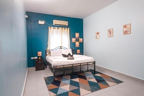 ein Schlafzimmer mit einem Bett und einer blauen Wand in der Unterkunft Abigail serene stay in Agarvado
