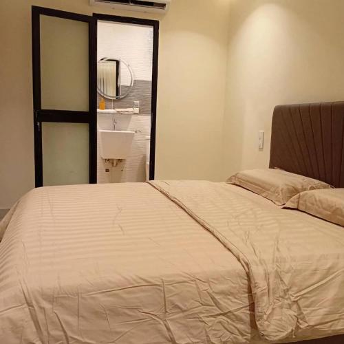 ein Schlafzimmer mit einem Bett mit Spiegel und Waschbecken in der Unterkunft Residence Helice in Kinshasa