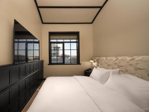 een slaapkamer met een groot bed en twee ramen bij 龄舍1927酒店 in Wuhan