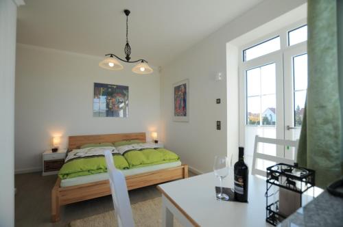 Un dormitorio con una cama con sábanas verdes y una mesa. en Villa Toskana, en Rothenburg ob der Tauber