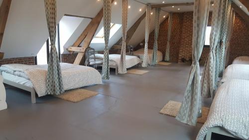 a room with three beds and rugs on the floor at Le Manoir d'Eole in Steenbecque