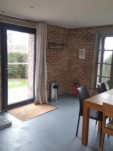 d'un salon avec une grande porte coulissante en verre. dans l'établissement Le Manoir d'Eole, à Steenbecque