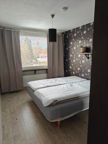 a bedroom with a bed in front of a window at Iso kolmio Torniossa in Tornio