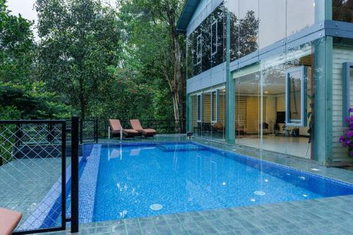 een zwembad naast een huis bij Stallion Estates in Munnar