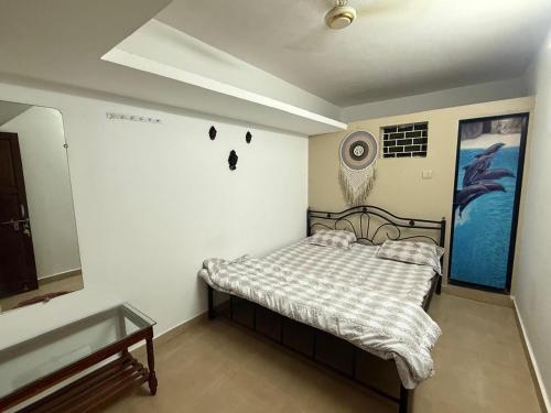 a bedroom with a bed and a painting on the wall at Trippy Turtle in Arambol