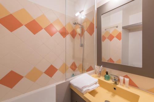 La salle de bains est pourvue d'un lavabo et d'une douche. dans l'établissement Résidence Pierre & Vacances La Promenade des Bains, à Saint-Raphaël