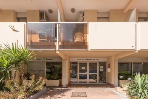 a facade of a building with glass doors and plants at Résidence Pierre & Vacances La Promenade des Bains in Saint-Raphaël