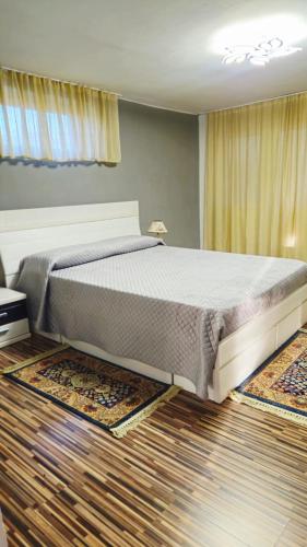 a large bed in a bedroom with rugs on the floor at Casa Sulfina in Radoşi