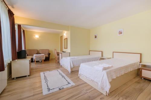 Habitación de hotel con 2 camas y sofá en Guesthouse Gostilitsa, en Gostilitsa