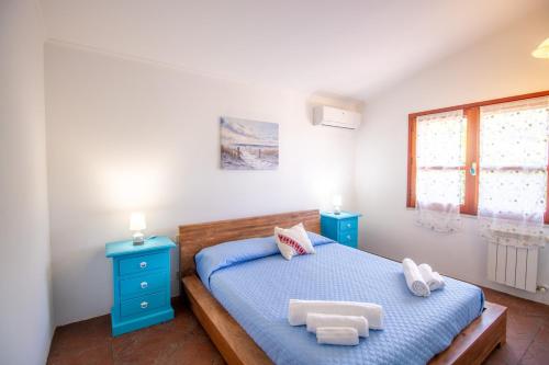 a bedroom with a blue bed and two blue night stands at S'Omu e Assunta in Cardedu