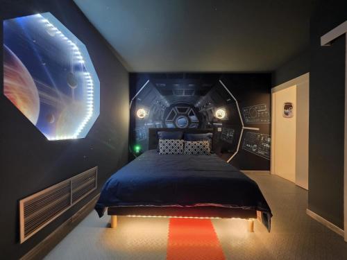 a bedroom with a bed with a star wars wall at La navette spatiale - Aventure - Espace - Clim - Parking in Toulouse