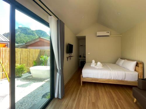 een slaapkamer met een bed, een bad en een raam bij Miramalin Resort Krabi in Ao Nang Beach