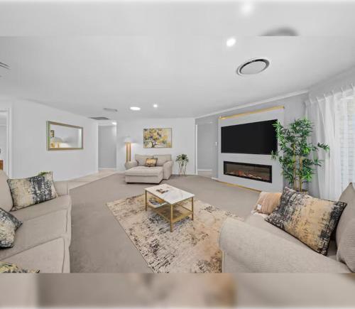 un salon avec deux canapés et une télévision dans l'établissement 4BR Coomera Views! Prime Gold Coast Near Beaches, à Gold Coast