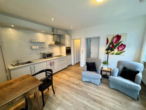 a kitchen and living room with two chairs and a table at Fewo KLÜN's 1 in Jever