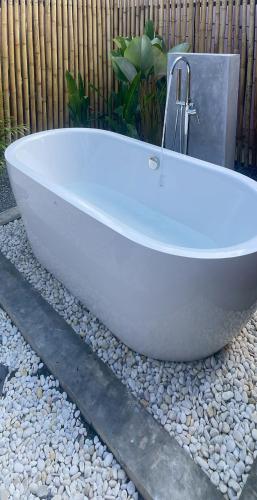 a white bath tub sitting on a bed of rocks at Miramalin Resort Krabi in Ao Nang Beach