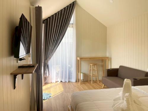 een slaapkamer met een bed, een bank en een raam bij Miramalin Resort Krabi in Ao Nang Beach