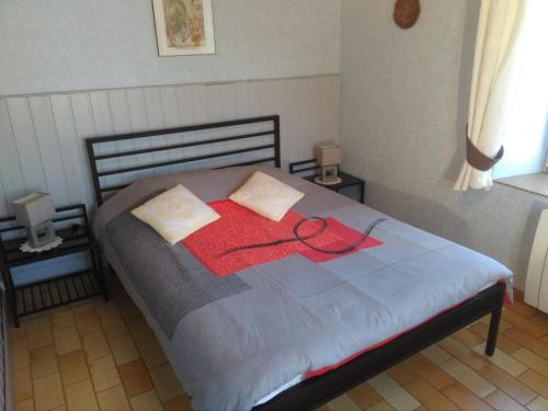 ein Bett mit einem roten Band darüber in der Unterkunft Gites & Camping on the Route des Vins in Bergheim