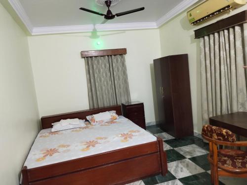 a bedroom with a bed and a ceiling fan at Chaps le guest house in Patna