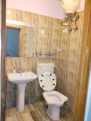 a bathroom with a toilet and a sink at Chaps le guest house in Patna