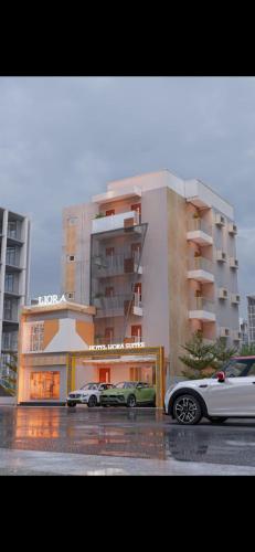 twee auto's geparkeerd voor een gebouw bij Hotel Liora Suites in Bangalore