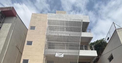 een hoog gebouw met een bord aan de zijkant bij Hotel Liora Suites in Bangalore