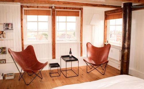 ハルリンゲンにあるHet Dakhuisのベッド付きの部屋に椅子2脚とテーブル1台が備わります。