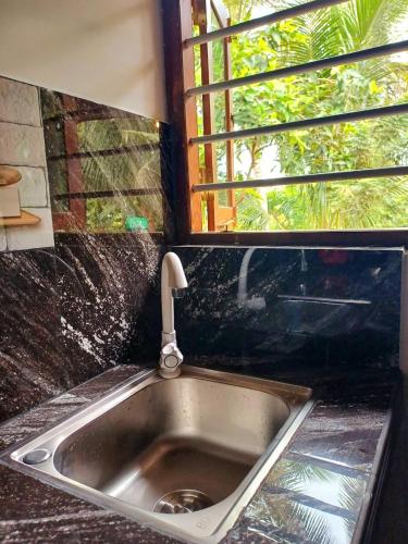 a kitchen sink with a faucet and a window at Turtle Island Cabana in Tangalle