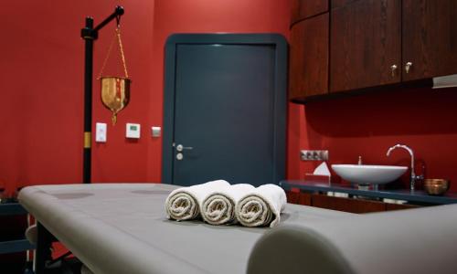 baño con paredes rojas y mesa con toallas en Diune Resort by Zdrojowa en Kołobrzeg