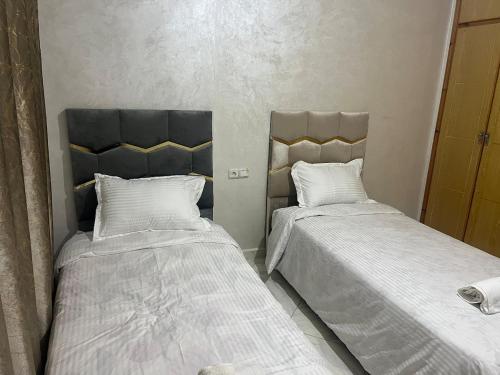 twee bedden naast elkaar in een slaapkamer bij Luxury University Apartment 3 in Fès