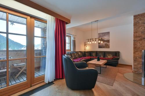 een woonkamer met een bank en een tafel bij Braito's Seaside Lodges und Suites, Ferienhäuser und Ferienwohnungen in Haldensee