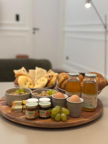 een schotel met eten, bijgerechten, brood en druiven bij Maison les Arcades - Collection AURA in Charleville-Mézières