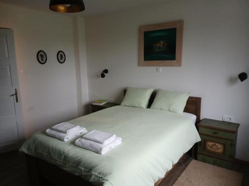 a bedroom with a white bed with towels on it at Kod bake in Oštarije