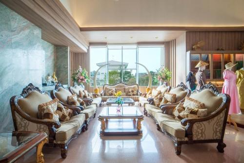 ein großes Wohnzimmer mit Sofas und einem Tisch in der Unterkunft Thongtarin Hotel in Surin