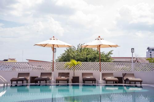 a swimming pool with chairs and umbrellas on a roof at Thongtarin Hotel in Surin