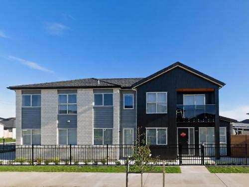 a house with a black roof at Modern New Home on Dungloe Ave, Central AC, 2 Kitchens, 3 livings in Auckland