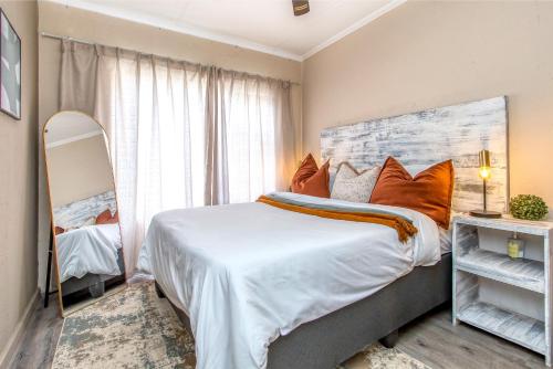 een slaapkamer met een groot bed met oranje kussens bij Retro Pop FREE Parking Fast Wifi Pool Large Workspace in Sandton