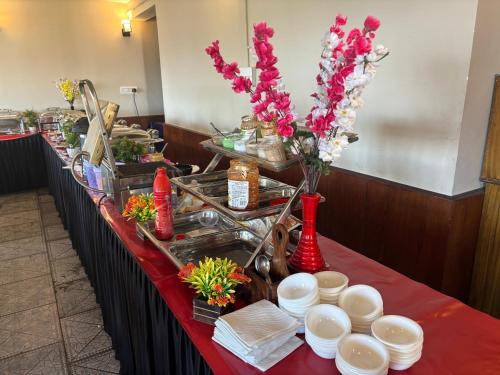 een lange tafel met borden en bloemen erop bij IVY The Boutique Hotel By Backpacker Stop in Nainital