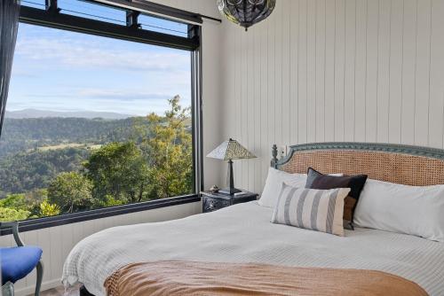een slaapkamer met een bed en een groot raam bij Escape to Serenity in Beechmont Luxurious Cabin Retreat in Beechmont