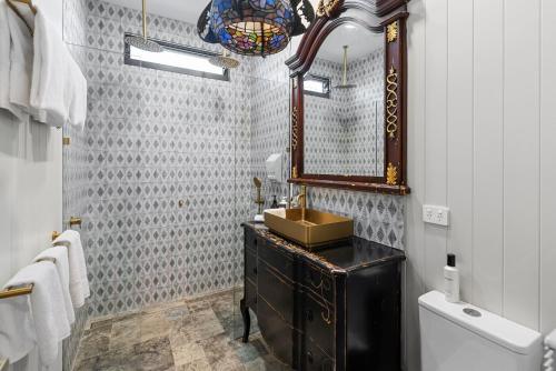 een badkamer met een wastafel en een spiegel en een toilet bij Escape to Serenity in Beechmont Luxurious Cabin Retreat in Beechmont