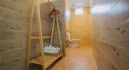 ein Bad mit einem WC und einer Holzwand in der Unterkunft May Trang Villa in Xuan An