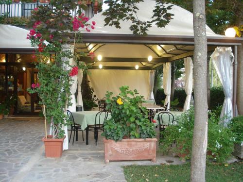 un patio con mesa, sillas y flores en Hotel da Rosanna, en Attigliano