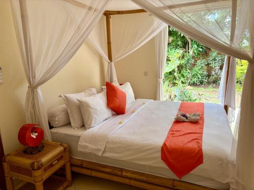 een slaapkamer met een hemelbed bij Beachfront Villa Mawar with Private Pool and Sunset View in Pengastulan