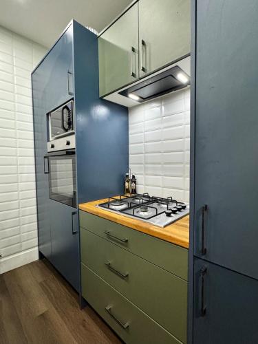 a small kitchen with a stove and a refrigerator at Flat in Manchester, 2 en-suite Beds, Etihad, Coop in Manchester
