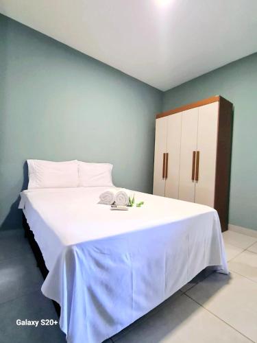 a bedroom with a large white bed with a cabinet at Brisa & Mar do Preá-700 m da praia e 12 km de Jeri in Jericoacoara