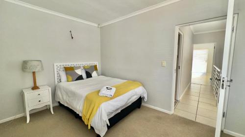 a bedroom with a bed with a yellow blanket at Maison Dauphine in Cape Town