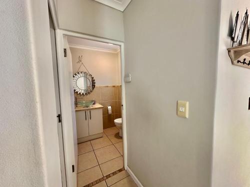 a small bathroom with a toilet and a sink at Maison Dauphine in Cape Town